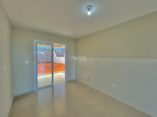 Interior de uma sala com porta de vidro que dá acesso a uma área externa.