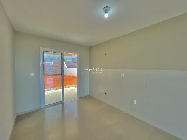 Interior de uma sala com porta de vidro que dá acesso a uma área externa.