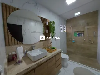 Este é um banheiro moderno com bancada de madeira e revestimento branco.
