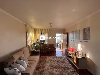 Sala de estar com sofá e cortinas em um ambiente interno.