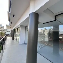 Hall de entrada com paredes brancas e piso claro em um apartamento.