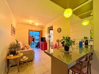 Sala de estar com piso de cerâmica clara e vista para a área externa.