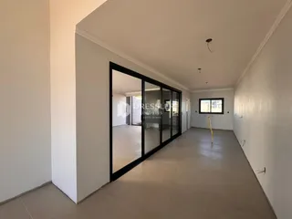 Interior de um espaço com portas de vidro e paredes brancas.