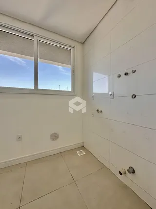 Vista interna de um cômodo com janela e instalações hidráulicas.