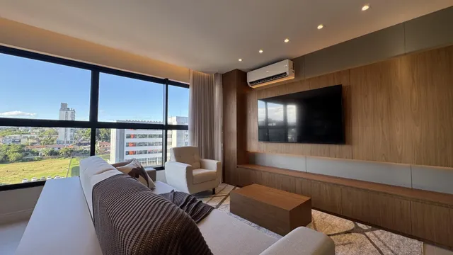 Sala de estar com sofá e grande janela com vista para a paisagem.