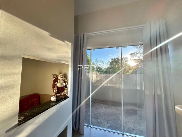 Vista interna de um ambiente com porta de vidro e reflexo de espelho.