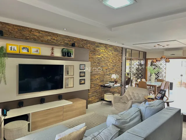 Sala de estar moderna com parede de pedra e televisão.