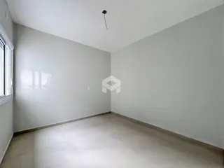 Foto de um cômodo vazio com paredes brancas e piso claro.