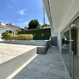 Varanda externa com piso de concreto e grade de vidro em Lajeado.
