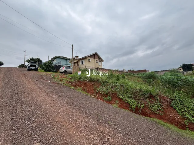 Vista da estrada de terra que sobe em direção a casas na paisagem.