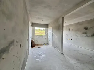 Hall de corredor com paredes brancas e piso de porcelanato em uma propriedade em Lajeado.