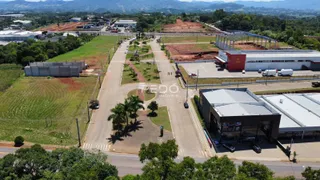 Vista aérea de uma propriedade com áreas verdes e construções industriais.