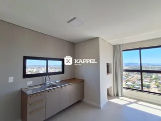 Cozinha moderna com bancada e grande janela com vista panorâmica.