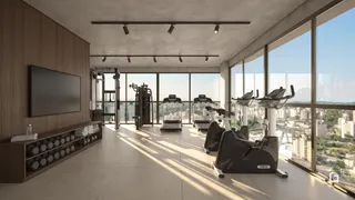 Ambiente interno amplo com grandes janelas e equipamentos de ginástica.