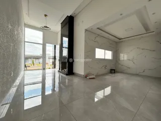 Sala de estar ampla com piso de porcelanato polido e grandes janelas.