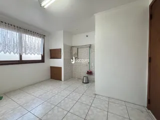 Ambiente interno com piso de cerâmica claro e janela.