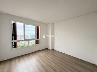 Ambiente interno com grande janela oferecendo vista da cidade.