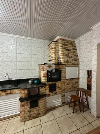 Foto de uma cozinha com parede de tijolos aparentes e revestimento branco.