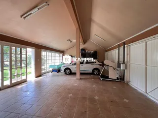 Ambiente amplo com piso de cerâmica e portas de vidro voltadas para o exterior.