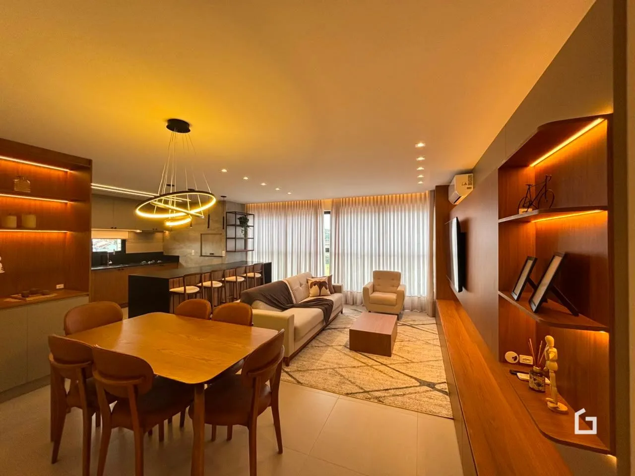 Sala de estar com área de jantar e cozinha integrada em um apartamento.