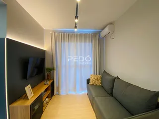 Sala de estar com sofá e televisão em um apartamento no Brasil.