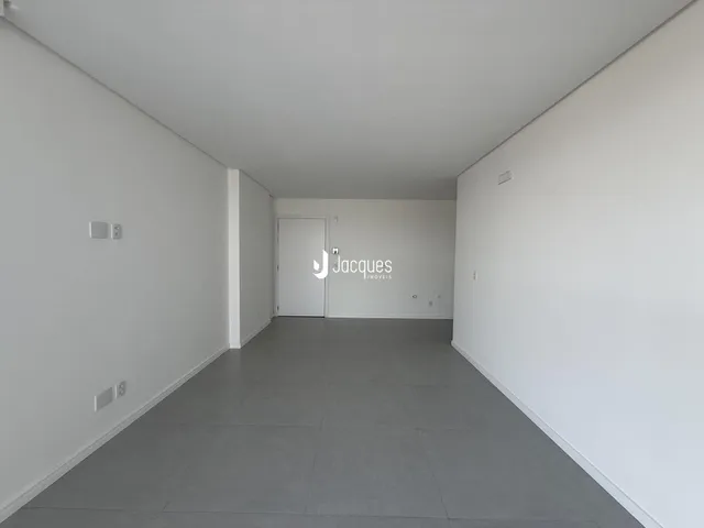 Corredor interno de um imóvel com paredes brancas e piso cinza.