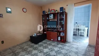 Sala de estar com paredes alaranjadas e piso de cerâmica.