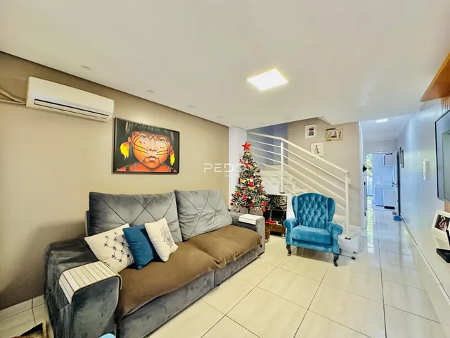 Sala de estar com sofá e escadaria moderna.