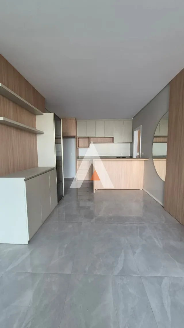 Ambiente de sala de estar e cozinha com piso de porcelanato cinza claro.