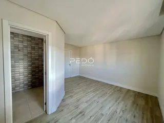 Vista de um ambiente interno com piso de madeira clara.