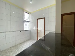 Corredor interno com paredes brancas e piso de cerâmica.