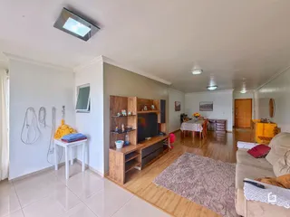 Interior de uma sala de estar com piso de madeira e móveis de madeira.