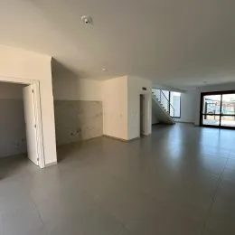 Hall de entrada amplo com piso de cerâmica e paredes brancas.