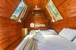 Quarto com paredes de madeira e cama grande.