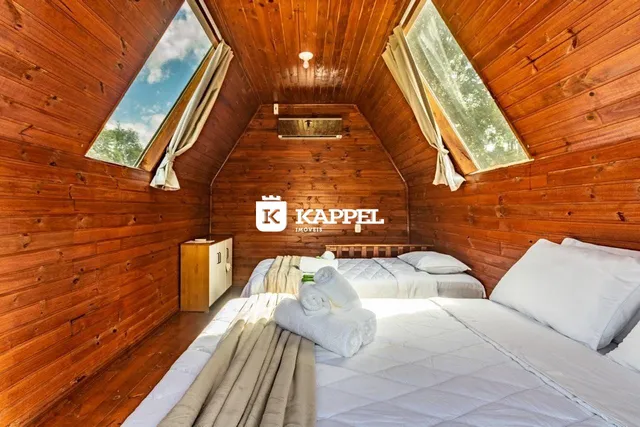 Quarto com paredes de madeira e cama grande.