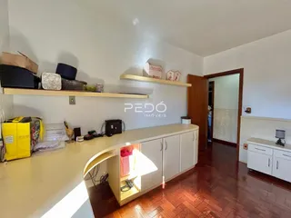Interior de uma sala com piso de madeira e estantes de madeira.