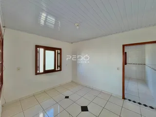 Interior de uma sala com piso de cerâmica clara e paredes brancas.