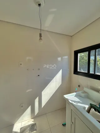 Foto do interior de um banheiro com piso de cerâmica claro e revestimento nas paredes.