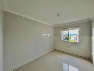 Ambiente interno de uma sala com piso claro e janela.