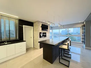 Sala de estar moderna com grandes janelas e piso claro.