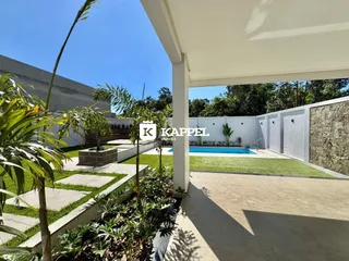 Vista externa mostrando uma piscina e área de jardim bem cuidada.