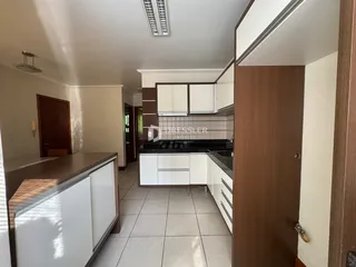 Foto de uma cozinha com armários brancos e piso de cerâmica.