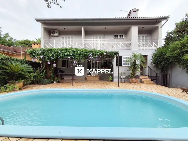 Foto da fachada de uma casa em Lajeado, Brasil, com uma piscina em primeiro plano.