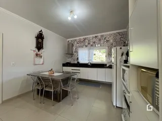 Ambiente de jantar e cozinha com piso cerâmico em imóvel no Brasil.