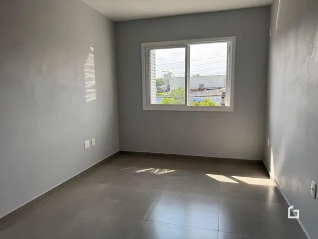 Foto de um cômodo interno com paredes brancas e piso de cerâmica.
