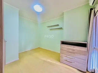 Quarto com paredes verde-claro e piso de madeira clara.