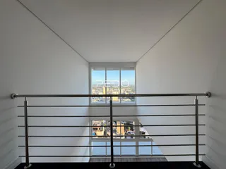 Corredor com janela oferecendo vista da cidade.