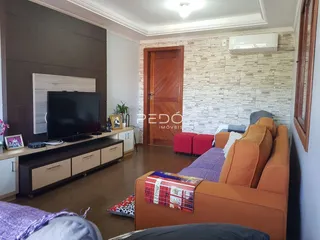 Sala de estar com sofá e televisão em ambiente residencial.