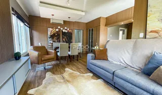 Sala de estar com sofá e poltrona em ambiente de madeira.