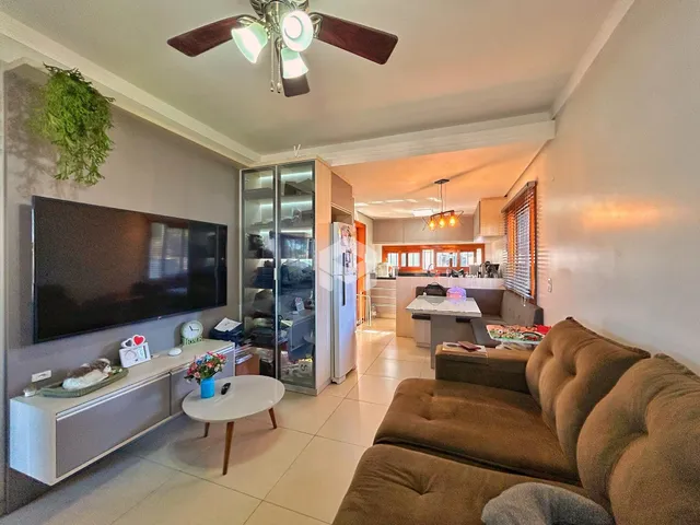 Sala de estar com televisão e cozinha em um apartamento no Brasil.